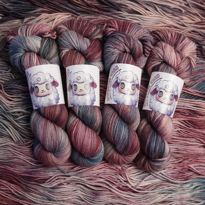 Twisted skeins of hand-dyed yarn featuring blended plum, blush, and slate gray colors, shown with illustrated sheep labels.