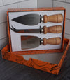 Three cheese knives with wood handles in an open gift box