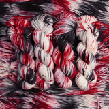 Bundles of red, black, and white yarn on a textured red and black background
