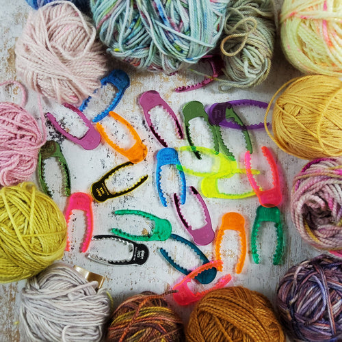 A pile of colorful acrylic skein locks among balls of yarn