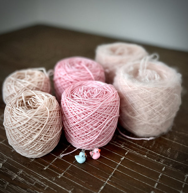 Pink yarn cakes for the Ranunculus pattern, including a fuzzy cake of Brushed Merino