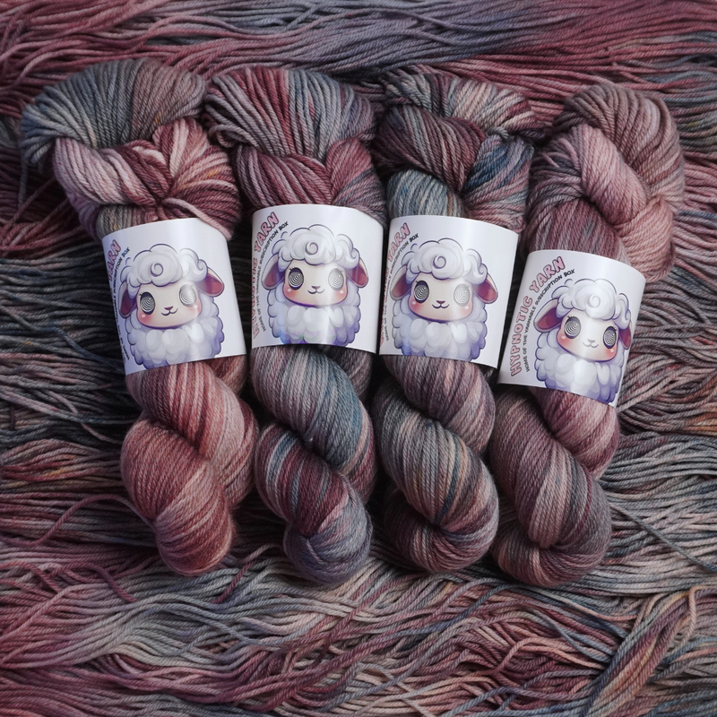 Twisted skeins of hand-dyed yarn featuring blended plum, blush, and slate gray colors, shown with illustrated sheep labels.