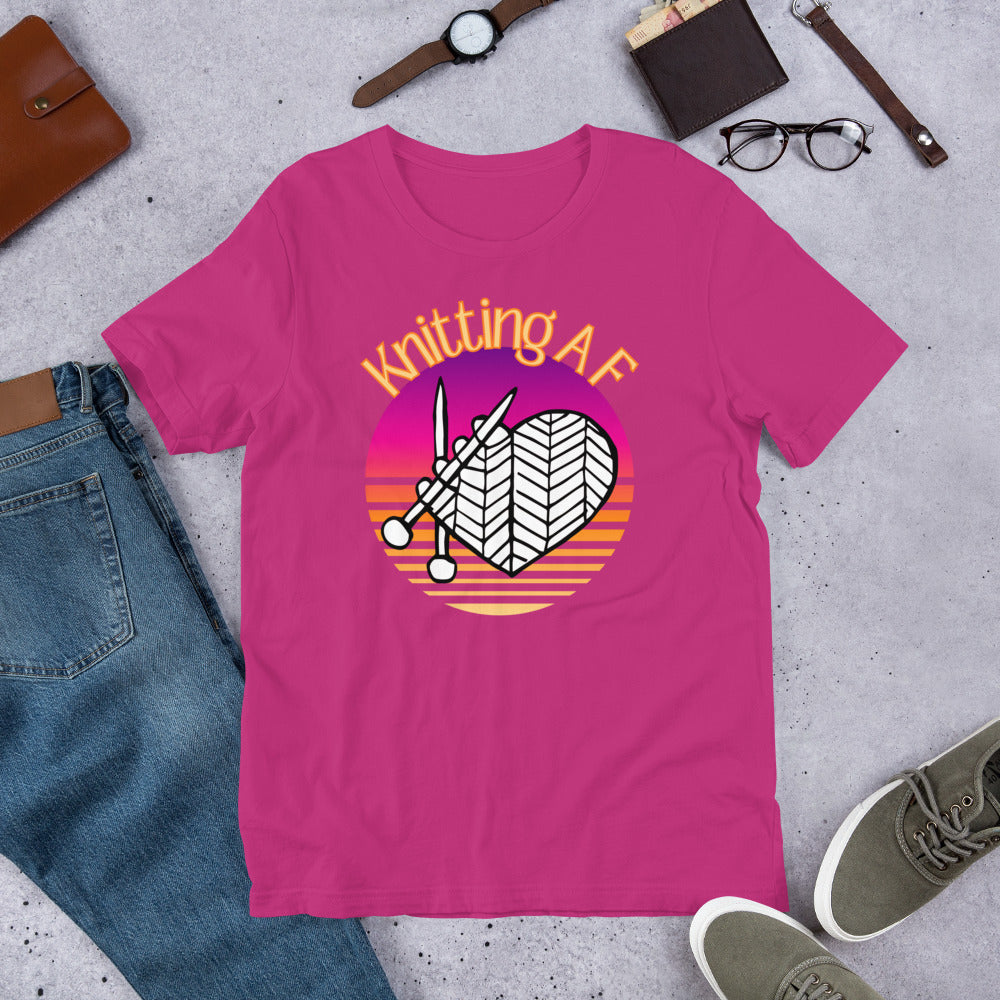 Berry scoop neck tee with the Knitting AF design in magenta and orange sunset stripes with knitting needles