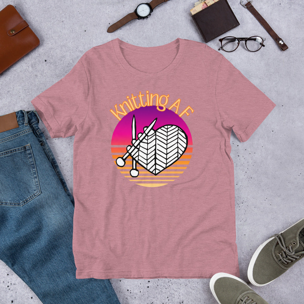Heather orchid scoop neck tee with the Knitting AF design in magenta and orange sunset stripes with knitting needles