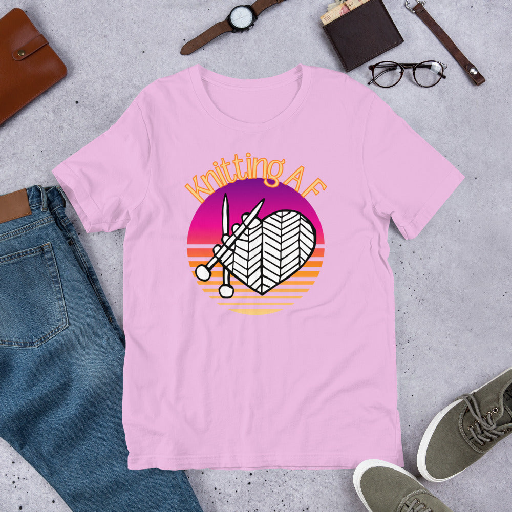 Lilac scoop neck tee with the Knitting AF design in magenta and orange sunset stripes with knitting needles