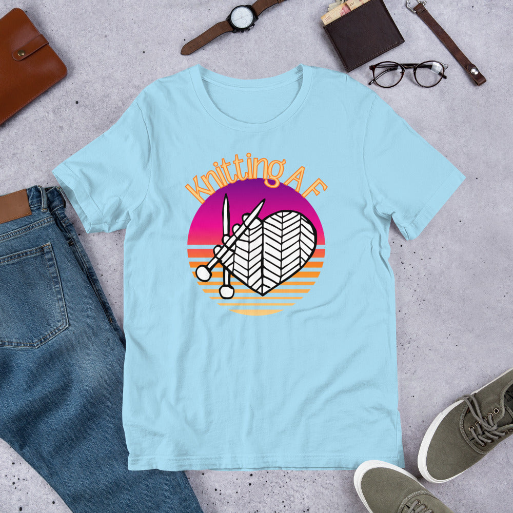 Ocean blue scoop neck tee with the Knitting AF design in magenta and orange sunset stripes with knitting needles