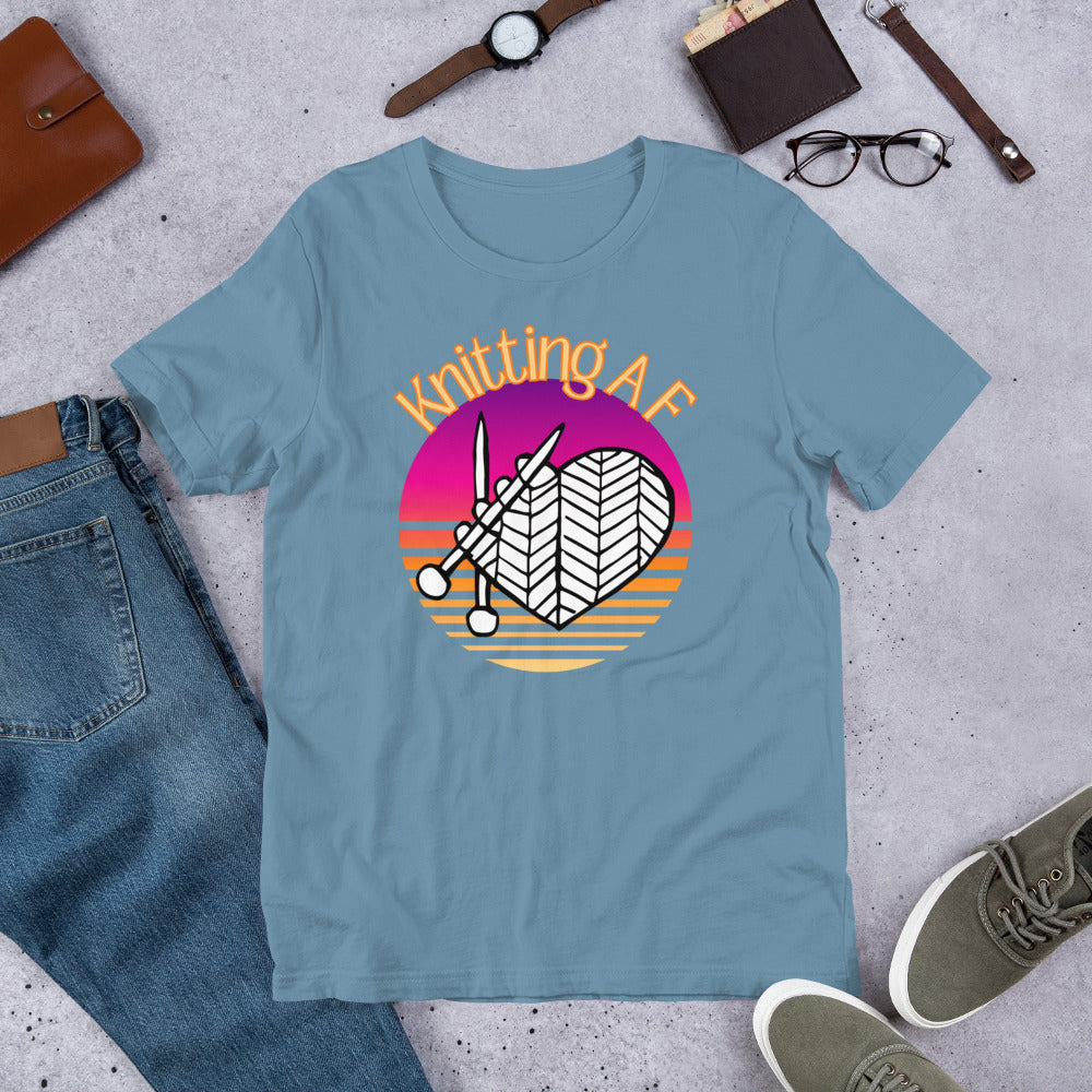 Steel blue scoop neck tee with the Knitting AF design in magenta and orange sunset stripes with knitting needles