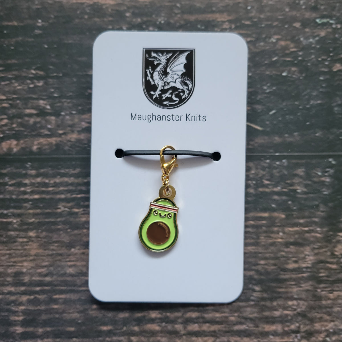 Avocado stitch marker with a heart on a Maughanster Knits card